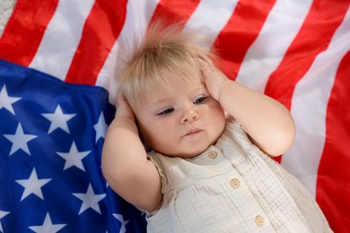 Photo of Cute little child on flag of USA, top view