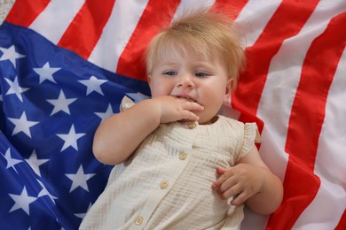 Photo of Cute little child on flag of USA, top view