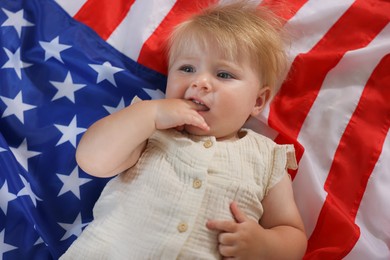 Photo of Cute little child on flag of USA, top view