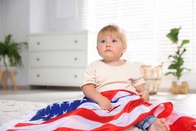 Photo of Cute little child with flag of USA on floor at home, space for text