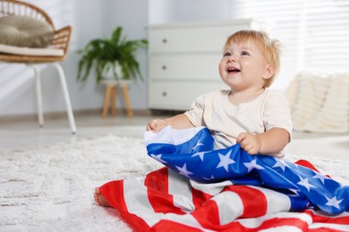 Photo of Cute little child with flag of USA on floor at home, space for text