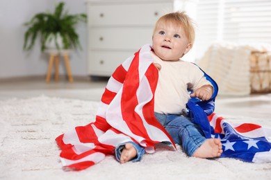 Photo of Cute little child with flag of USA on floor at home, space for text