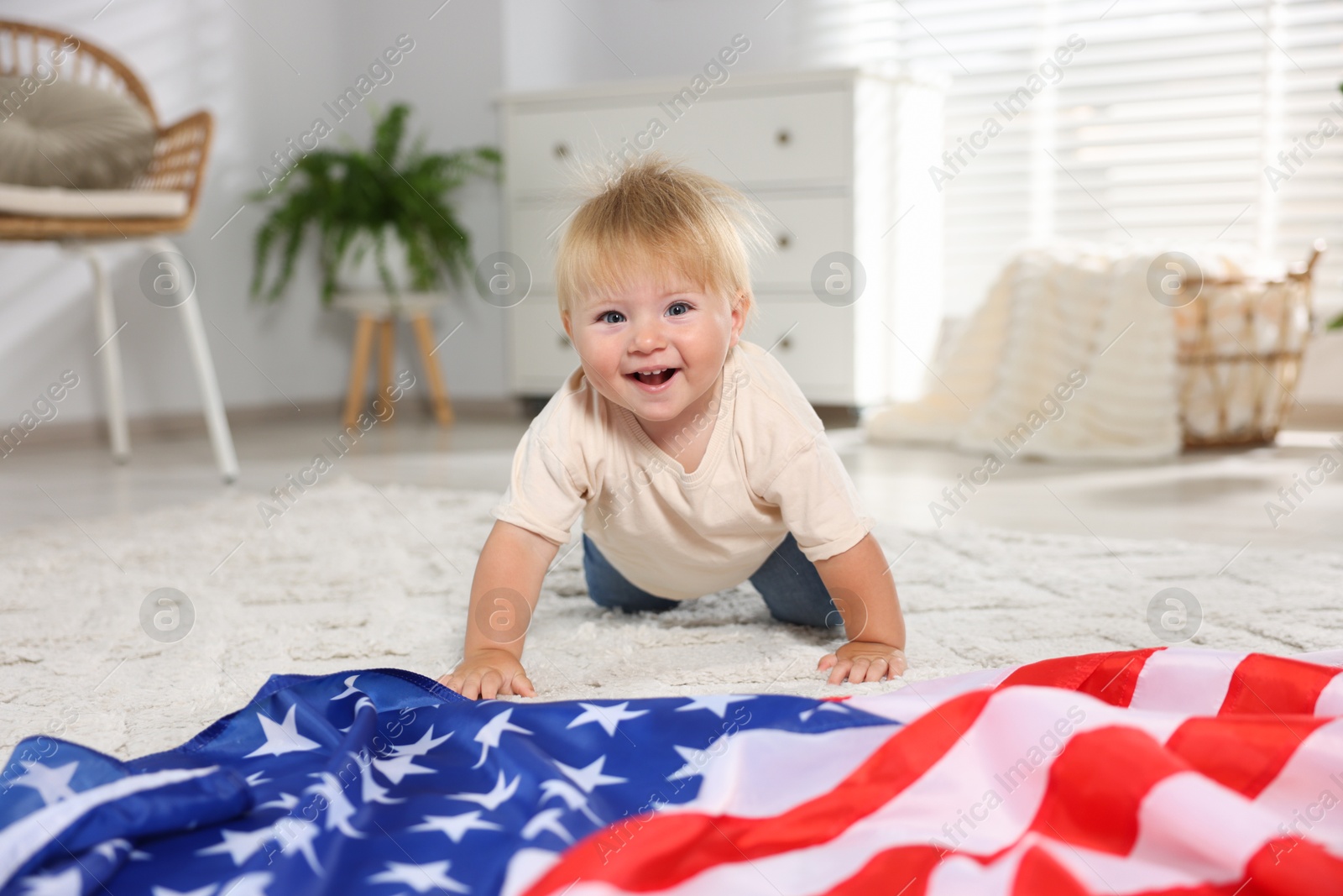 Photo of Cute little child with flag of USA on floor at home