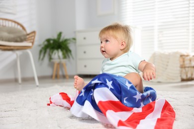 Photo of Cute little child with flag of USA on floor at home, space for text