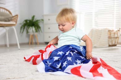 Photo of Cute little child with flag of USA on floor at home, space for text