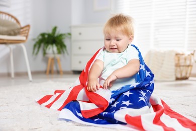 Photo of Cute little child with flag of USA on floor at home, space for text