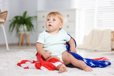 Photo of Cute little child with flag of USA on floor at home