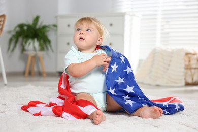 Photo of Cute little child with flag of USA on floor at home