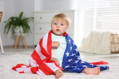 Photo of Cute little child with flag of USA on floor at home