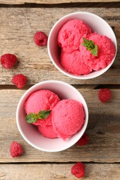 Photo of Delicious raspberry sorbet with mint in bowls and fresh berries on wooden table, flat lay