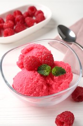 Photo of Delicious raspberry sorbet with mint in bowl and fresh berries on white wooden table, closeup