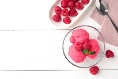 Photo of Delicious raspberry sorbet with mint in bowl, spoon and fresh berries on white wooden table, flat lay. Space for text