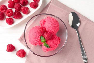 Photo of Delicious raspberry sorbet with mint in bowl, spoon and fresh berries on white wooden table, flat lay