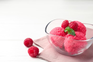 Photo of Delicious raspberry sorbet with mint in bowl, napkin and fresh berries on white wooden table, closeup