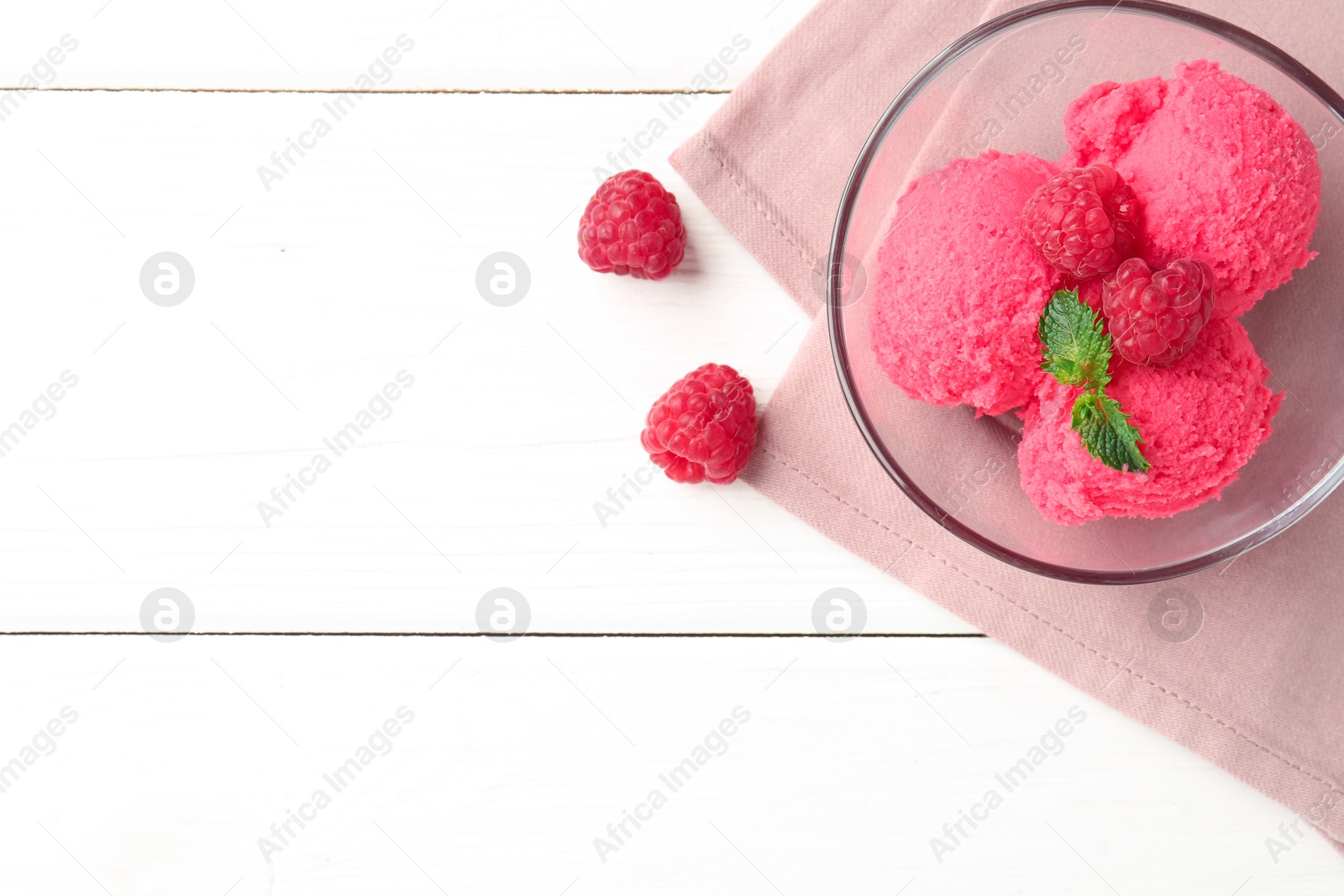 Photo of Delicious raspberry sorbet with mint in bowl, napkin and fresh berries on white wooden table, flat lay. Space for text