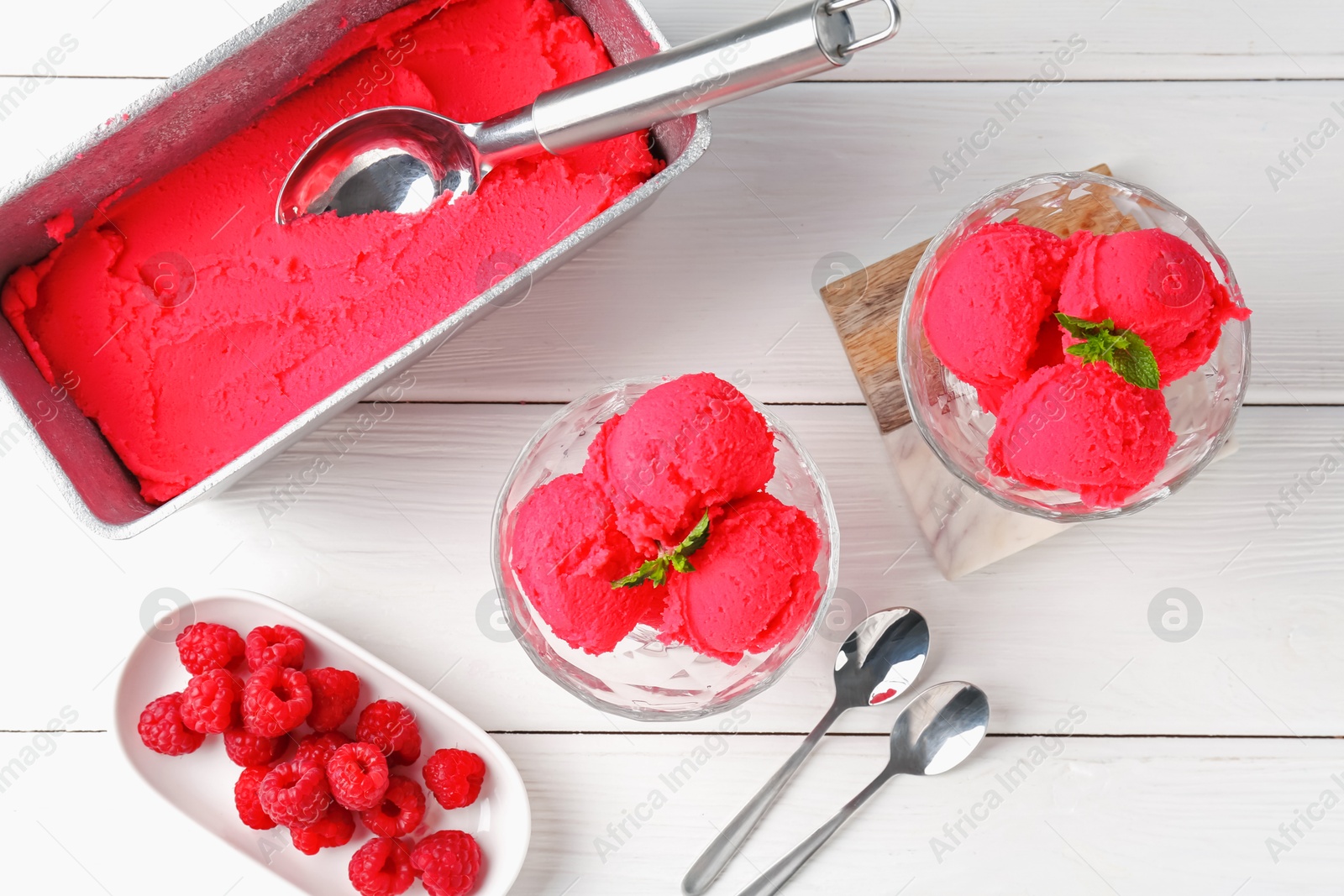 Photo of Delicious raspberry sorbet with mint and fresh berries served on white wooden table, flat lay