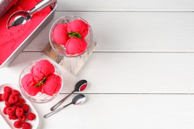 Photo of Delicious raspberry sorbet with mint and fresh berries served on white wooden table, flat lay. Space for text