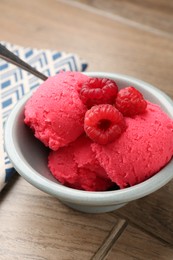 Photo of Delicious raspberry sorbet with fresh berries in bowl on wooden table, closeup