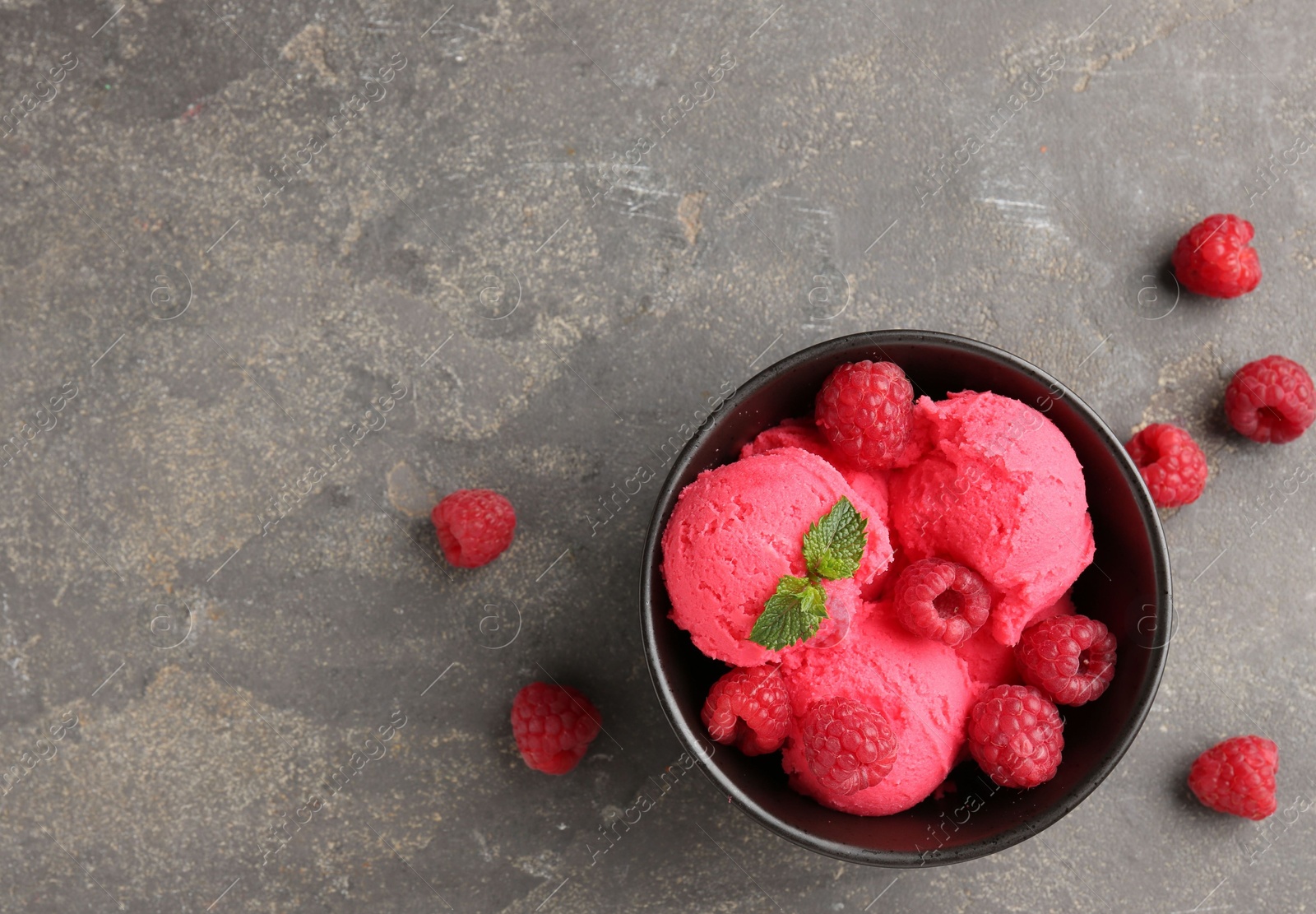 Delicious raspberry sorbet with fresh berries and mint in bowl on grey textured table, flat lay. Space for text Photo of Delicious raspberry sorbet with fresh berries and mint in bowl on grey textured table, flat lay. Space for text