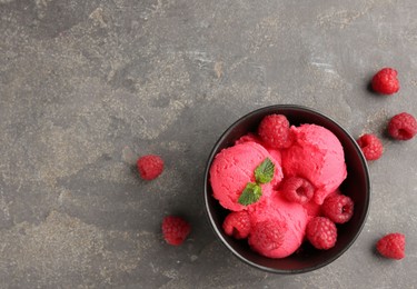 Photo of Delicious raspberry sorbet with fresh berries and mint in bowl on grey textured table, flat lay. Space for text