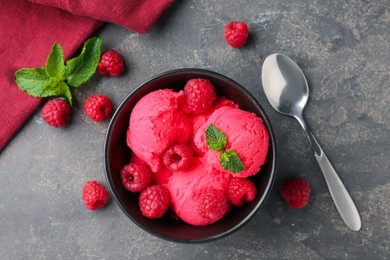 Photo of Delicious raspberry sorbet with fresh berries and mint in bowl served on grey textured table, flat lay
