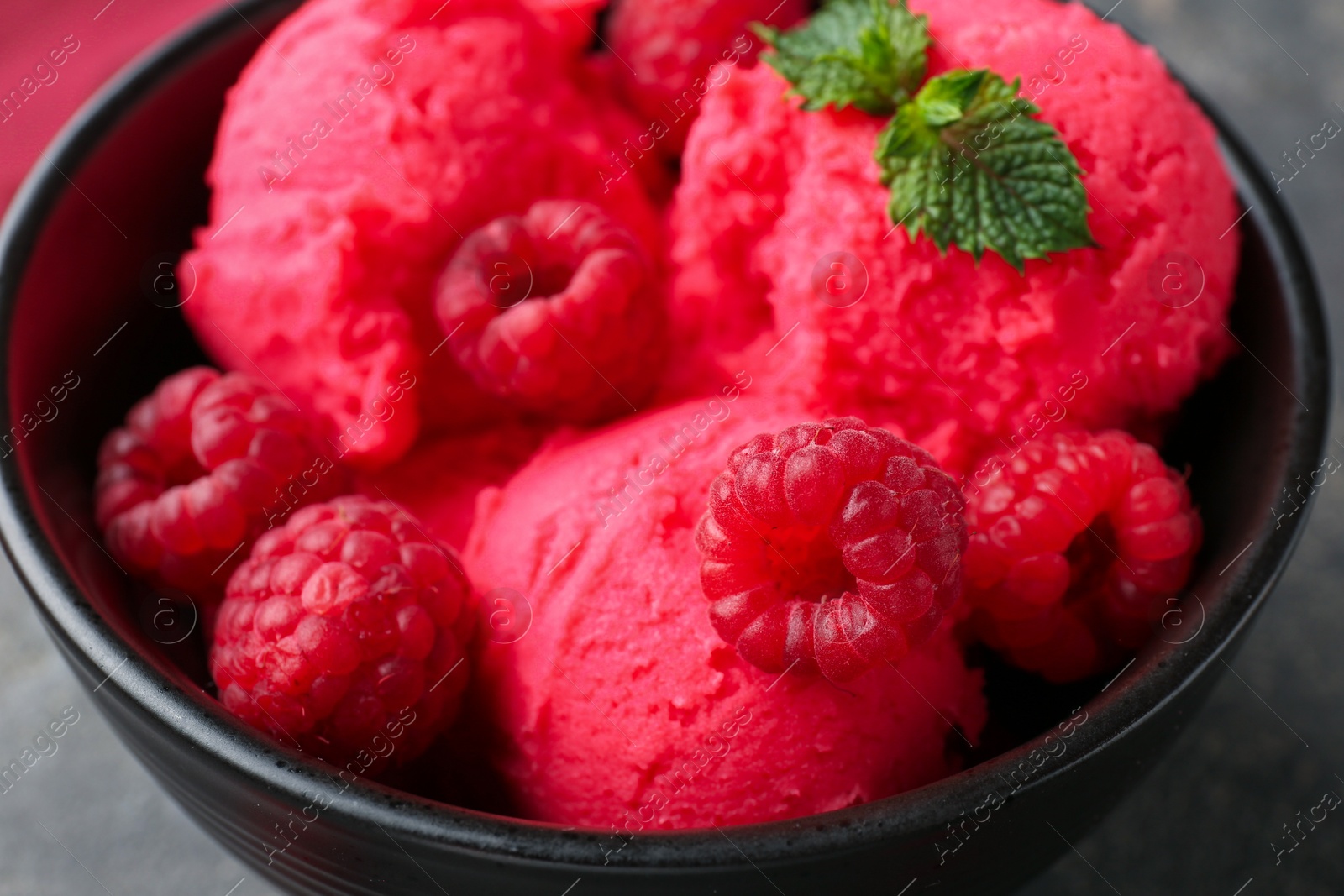 Delicious raspberry sorbet with fresh berries and mint in bowl on grey table, closeup Photo of Delicious raspberry sorbet with fresh berries and mint in bowl on grey table, closeup