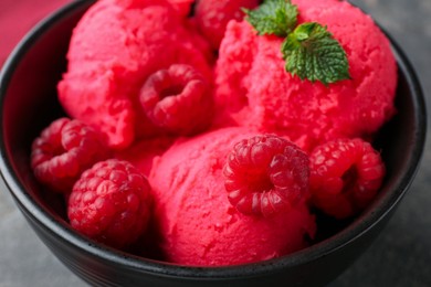 Photo of Delicious raspberry sorbet with fresh berries and mint in bowl on grey table, closeup
