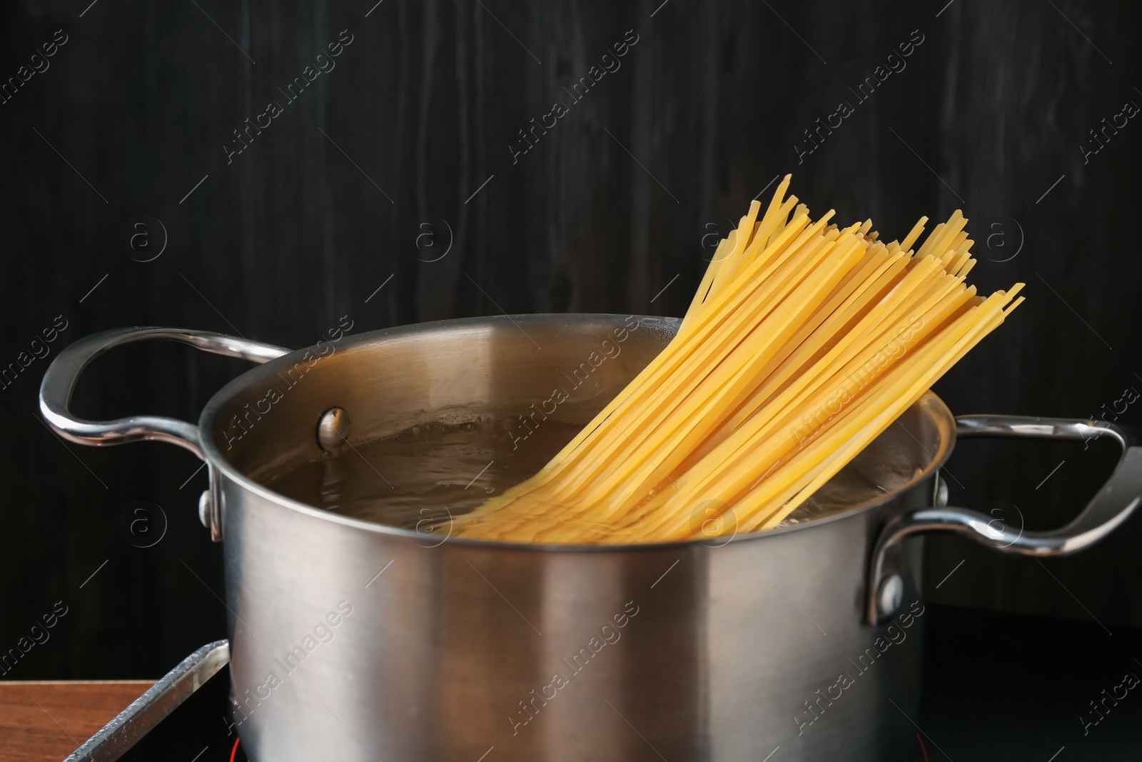 Fresh tagliatelle pasta boiling in pot with water on electric stove, closeup Photo of Fresh tagliatelle pasta boiling in pot with water on electric stove, closeup