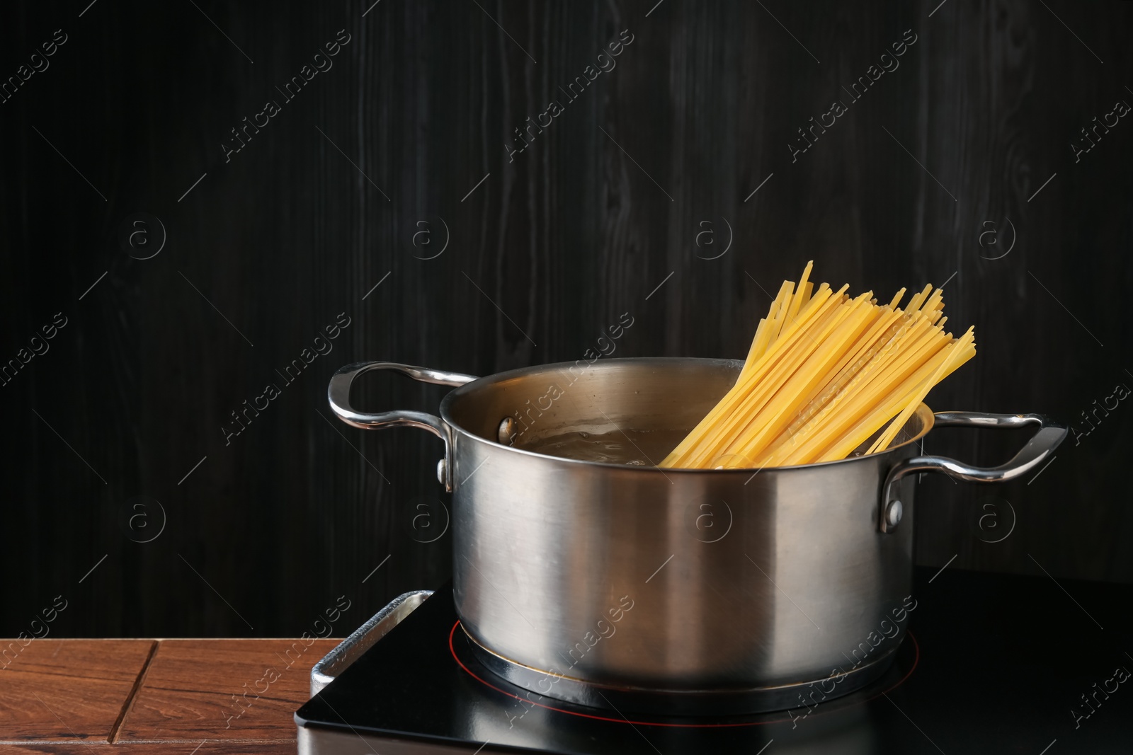 Fresh tagliatelle pasta boiling in pot with water on electric stove Photo of Fresh tagliatelle pasta boiling in pot with water on electric stove