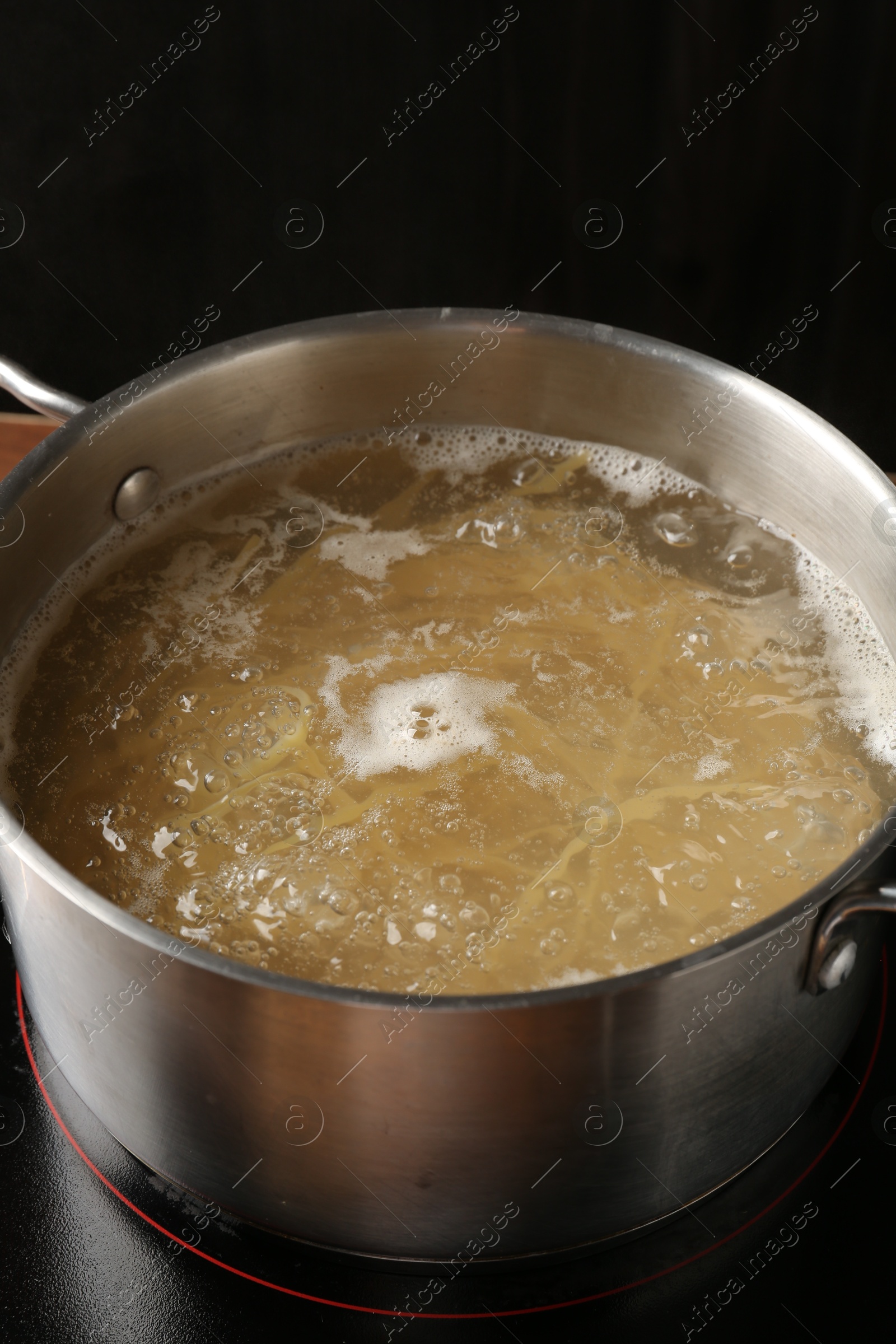 Fresh tagliatelle pasta boiling in pot with water on electric stove, closeup Photo of Fresh tagliatelle pasta boiling in pot with water on electric stove, closeup