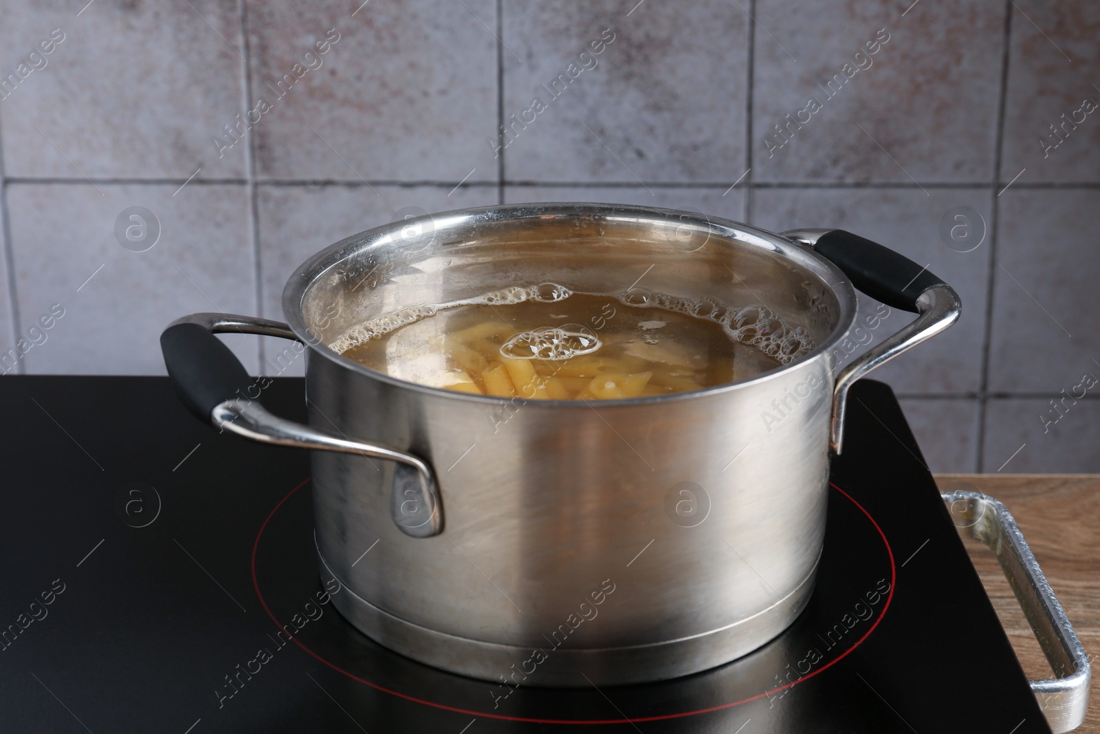 Fresh pasta boiling in pot with water on electric stove, closeup Photo of Fresh pasta boiling in pot with water on electric stove, closeup