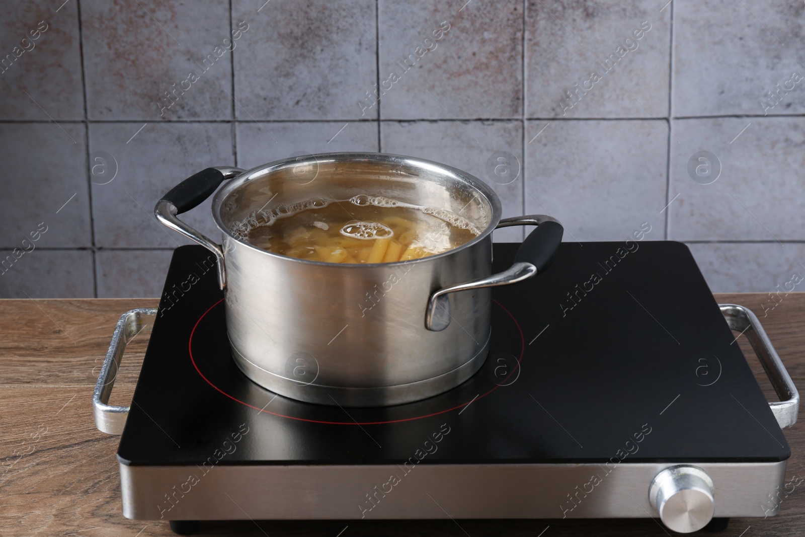 Fresh pasta boiling in pot with water on electric stove Photo of Fresh pasta boiling in pot with water on electric stove