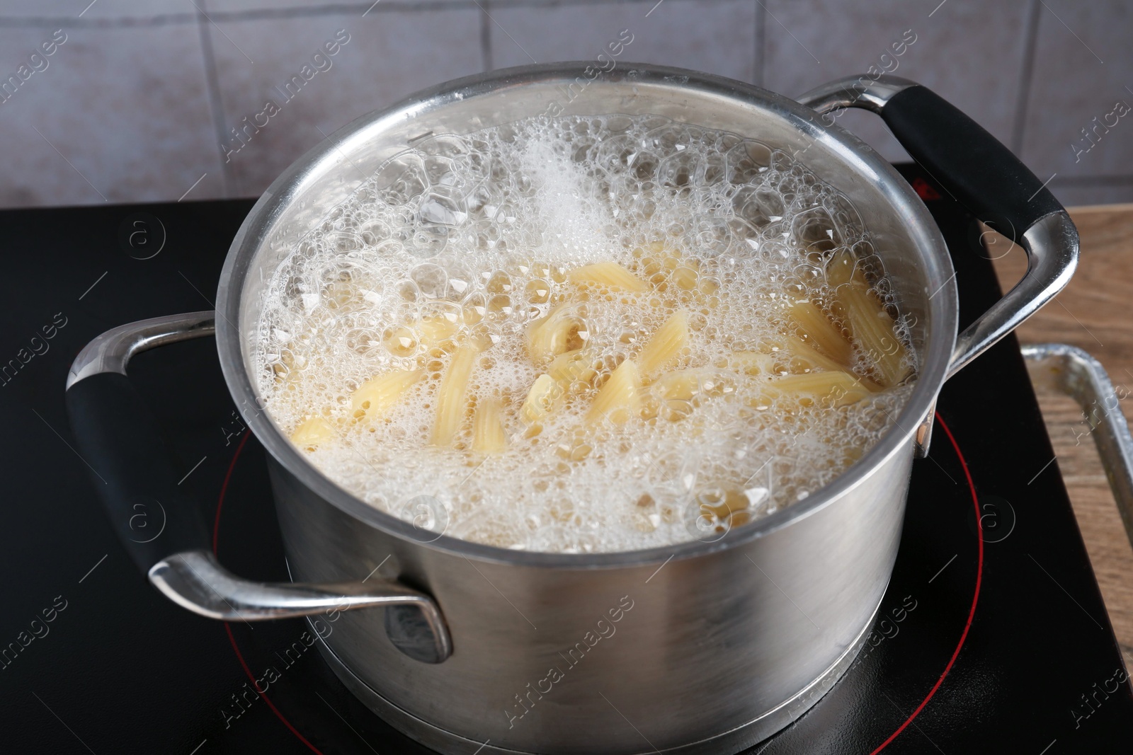 Fresh pasta boiling in pot with water on electric stove, closeup Photo of Fresh pasta boiling in pot with water on electric stove, closeup