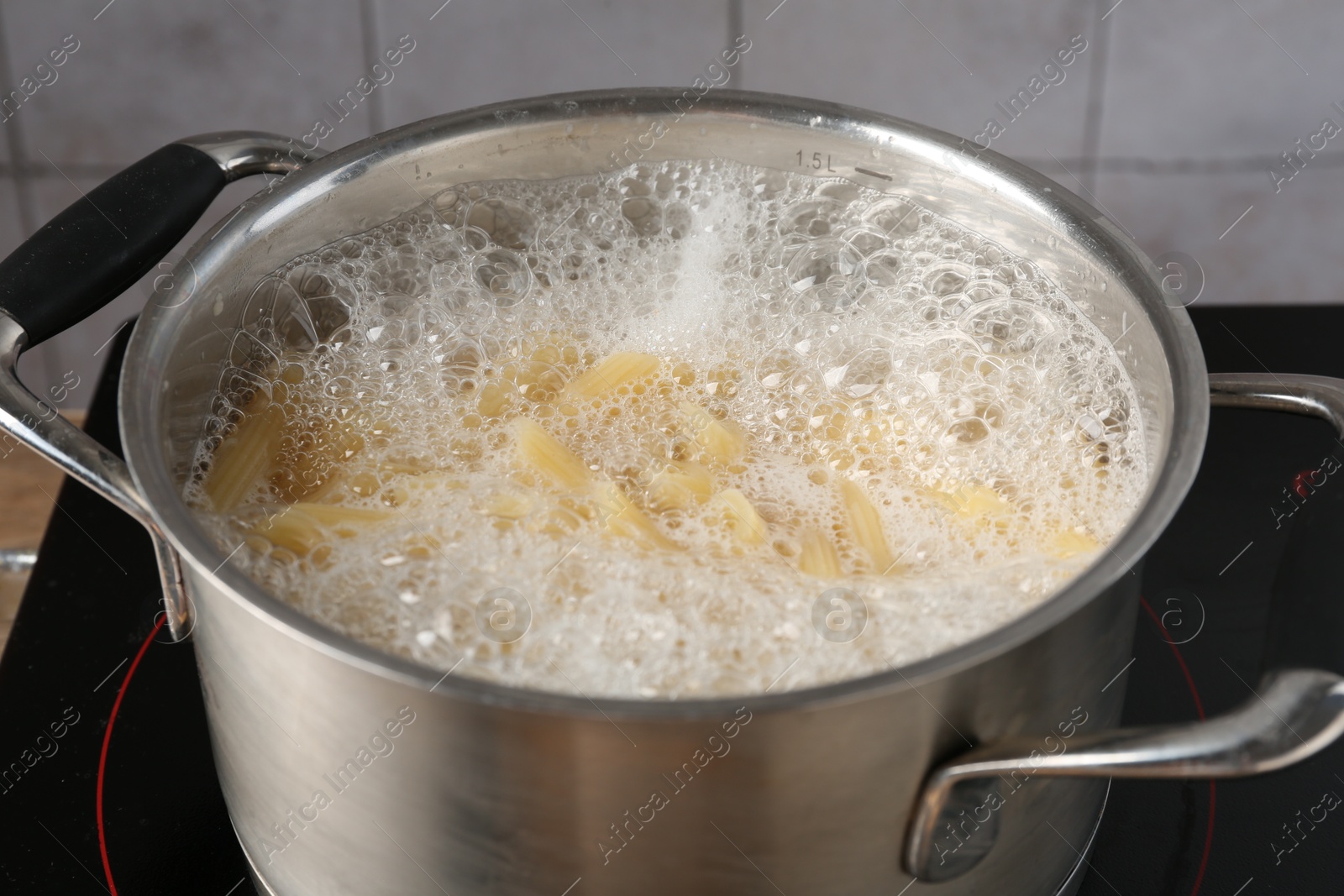 Fresh pasta boiling in pot with water on electric stove, closeup Photo of Fresh pasta boiling in pot with water on electric stove, closeup