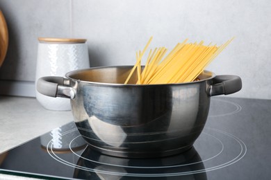 Photo of Fresh tagliatelle pasta boiling in pot on electric stove