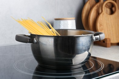 Photo of Fresh tagliatelle pasta boiling in pot on electric stove