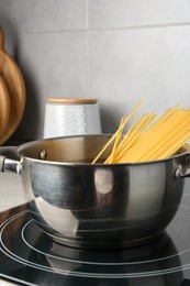 Photo of Fresh tagliatelle pasta boiling in pot on electric stove