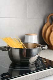 Photo of Fresh tagliatelle pasta boiling in pot on electric stove