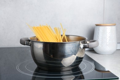 Photo of Fresh tagliatelle pasta boiling in pot on electric stove