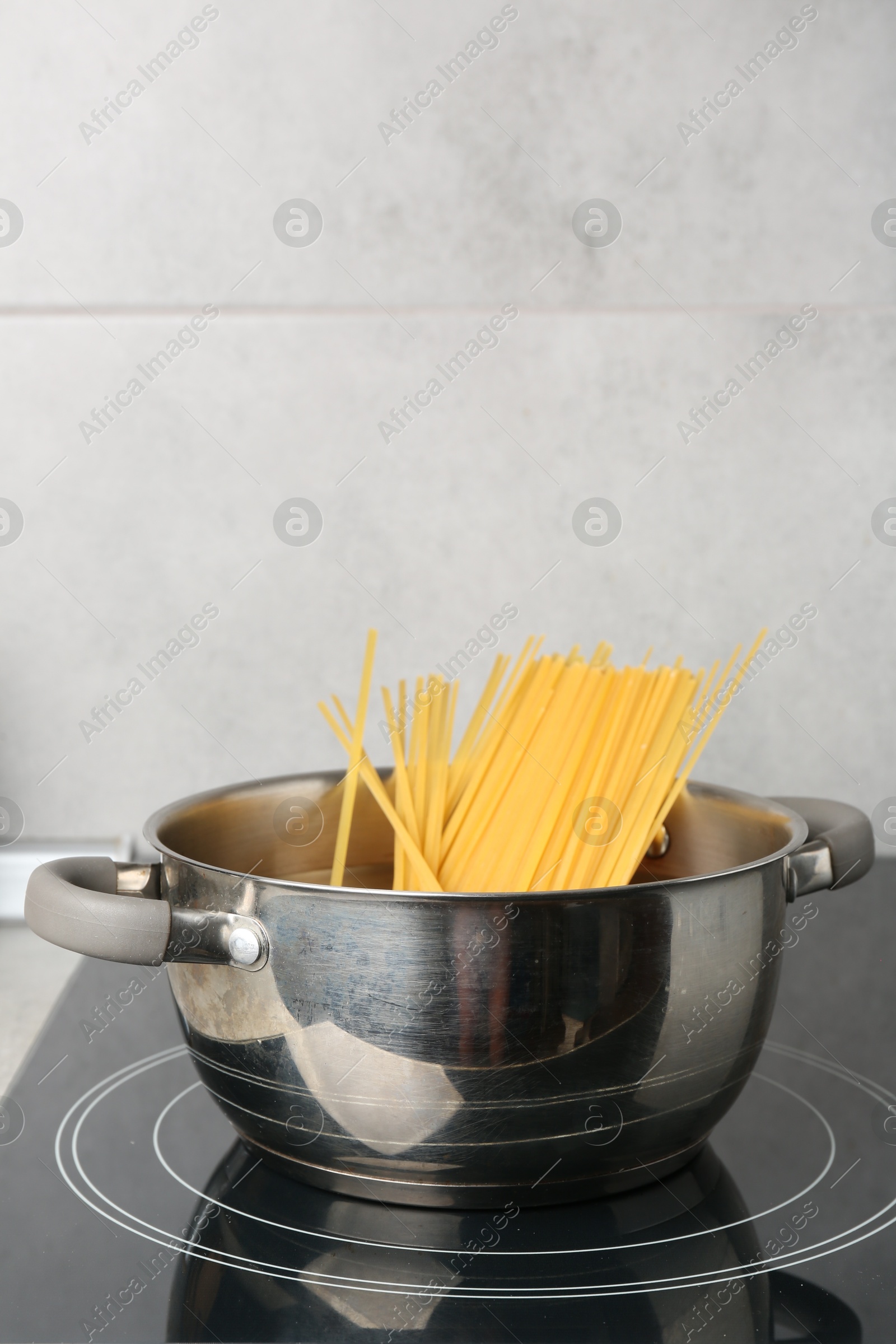 Fresh tagliatelle pasta boiling in pot on electric stove Photo of Fresh tagliatelle pasta boiling in pot on electric stove