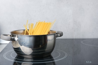 Photo of Fresh tagliatelle pasta boiling in pot on electric stove, space for text