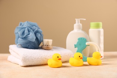 Photo of Baby accessories and bathing products on beige textured table