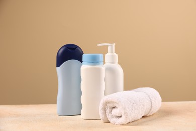 Photo of Baby accessories and bathing products on beige textured table