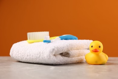 Photo of Baby accessories and bathing products on grey table against orange background, closeup