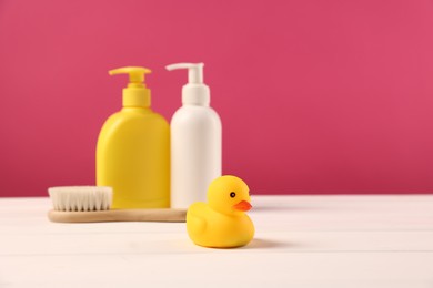 Photo of Baby accessories and bathing products on white wooden table against pink background, space for text