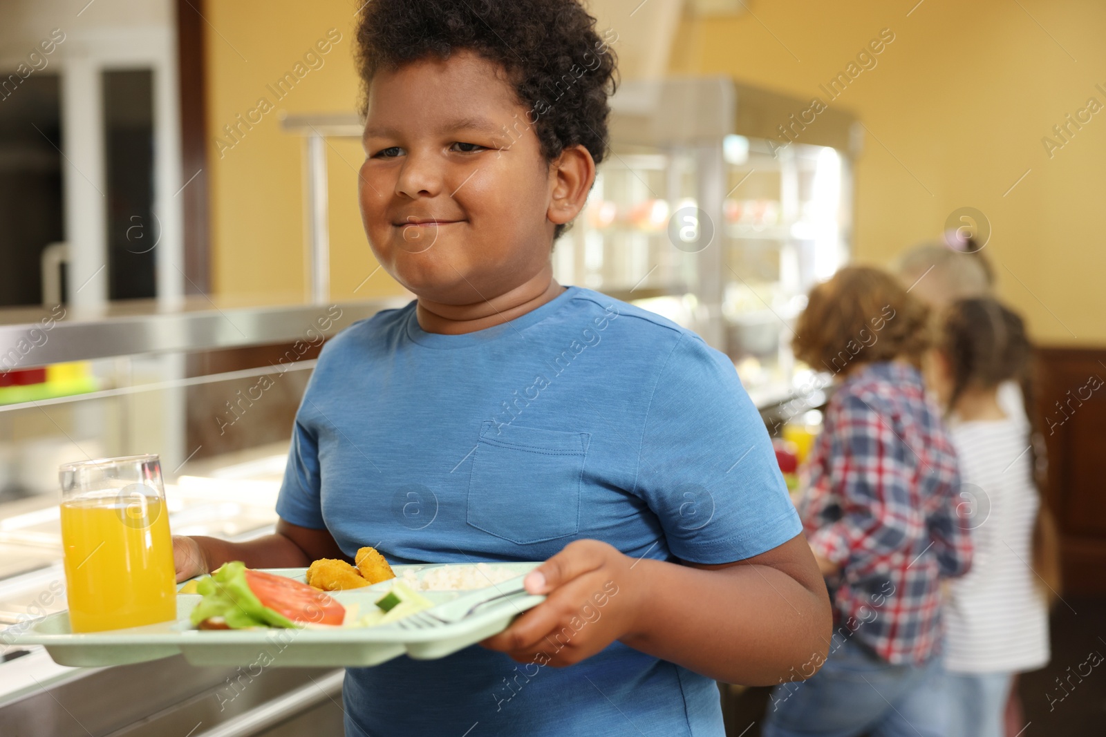 Little boy with tray of tasty food in school canteen, selective focus Photo of Little boy with tray of tasty food in school canteen, selective focus