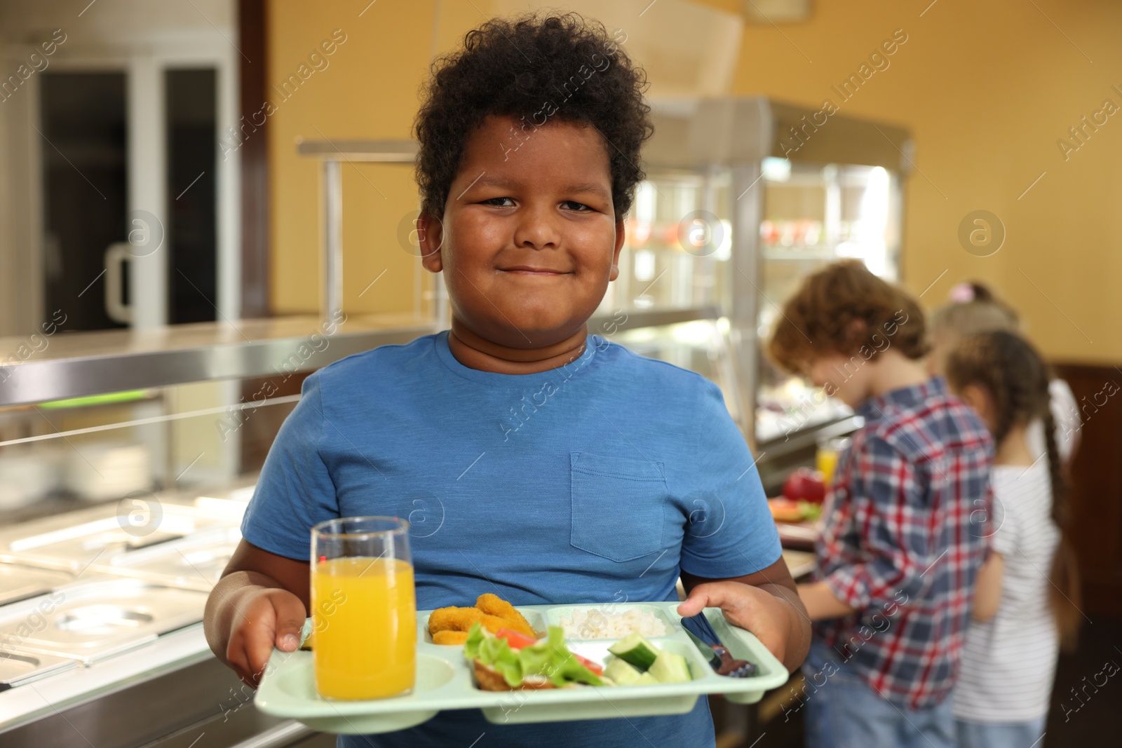 Little boy with tray of tasty food in school canteen, selective focus Photo of Little boy with tray of tasty food in school canteen, selective focus