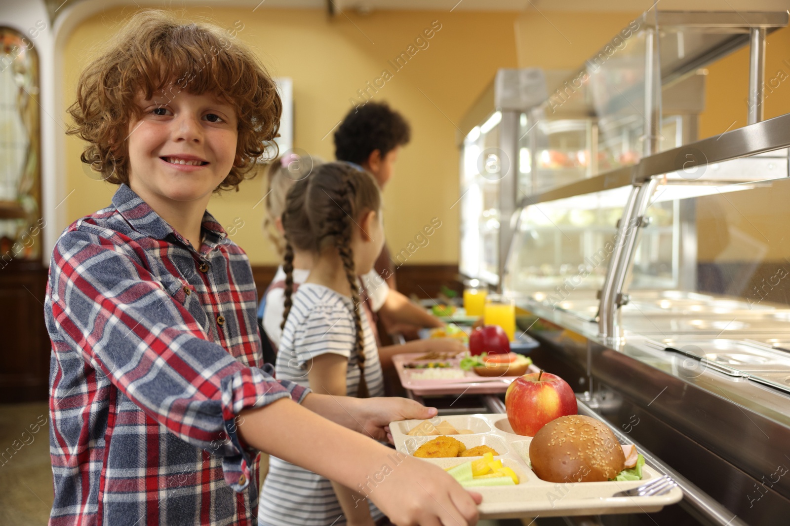 Little boy with tray of tasty food in school canteen, selective focus Photo of Little boy with tray of tasty food in school canteen, selective focus