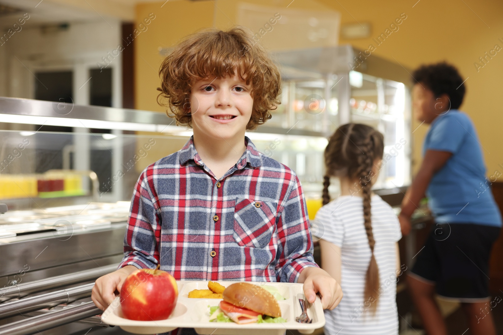 Little boy with tray of tasty food in school canteen, selective focus Photo of Little boy with tray of tasty food in school canteen, selective focus