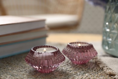 Photo of Spa composition with burning candles and books on table, closeup